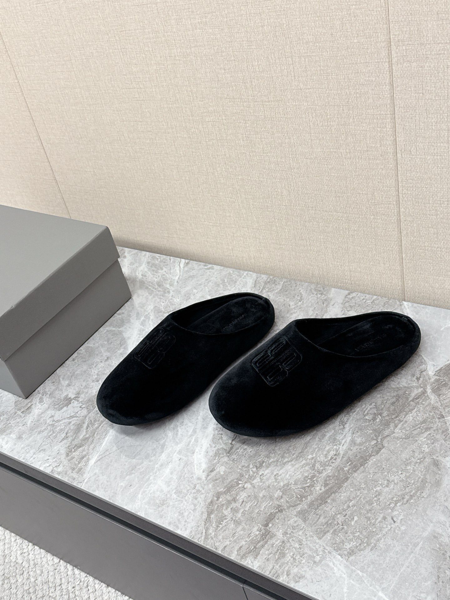Black slide sandals with embossed Balenciaga logo, side-by-side view