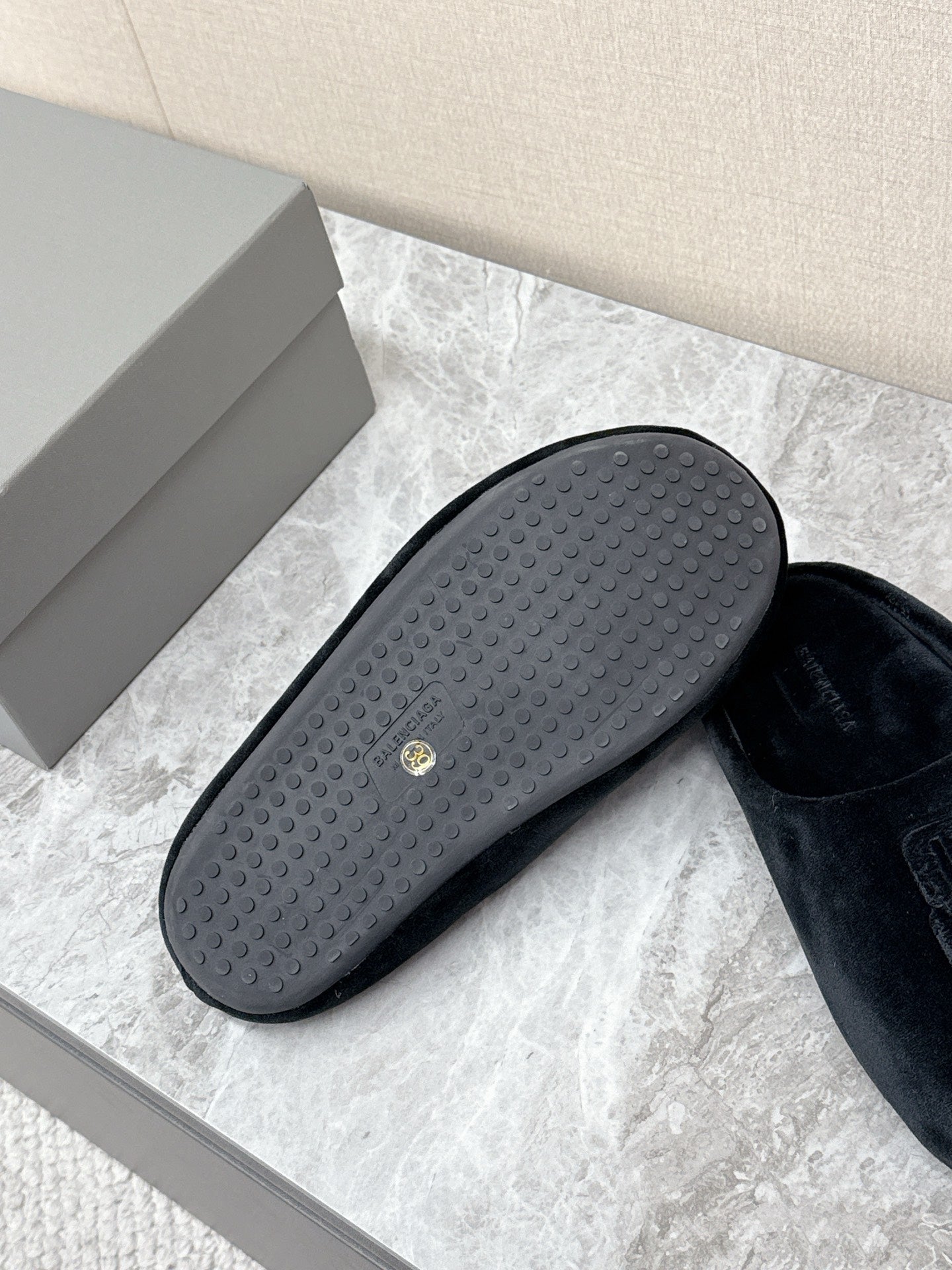 Rubber outsole for black slide sandals, textured grip tread with small logo