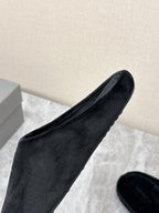 Black velvet slide sandal with embossed Balenciaga logo, angled close-up