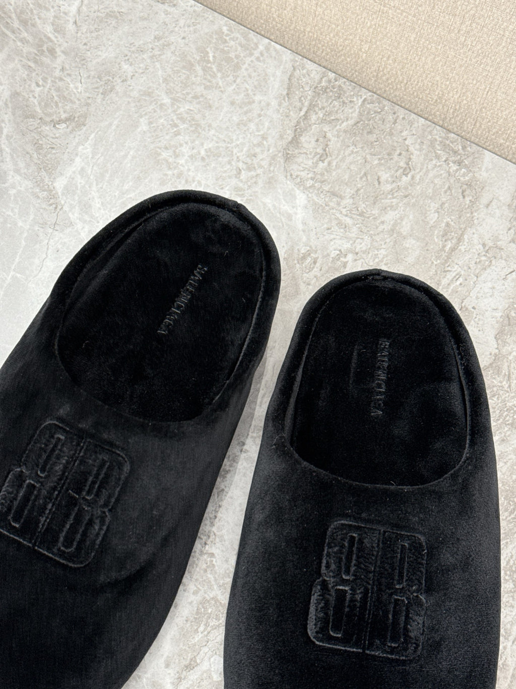 Black velvet slide sandals with embossed Balenciaga logo detail, close-up