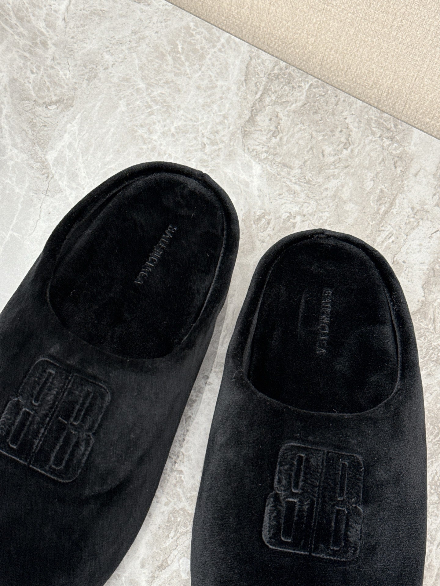 Black velvet slide sandals with embossed Balenciaga logo detail, close-up