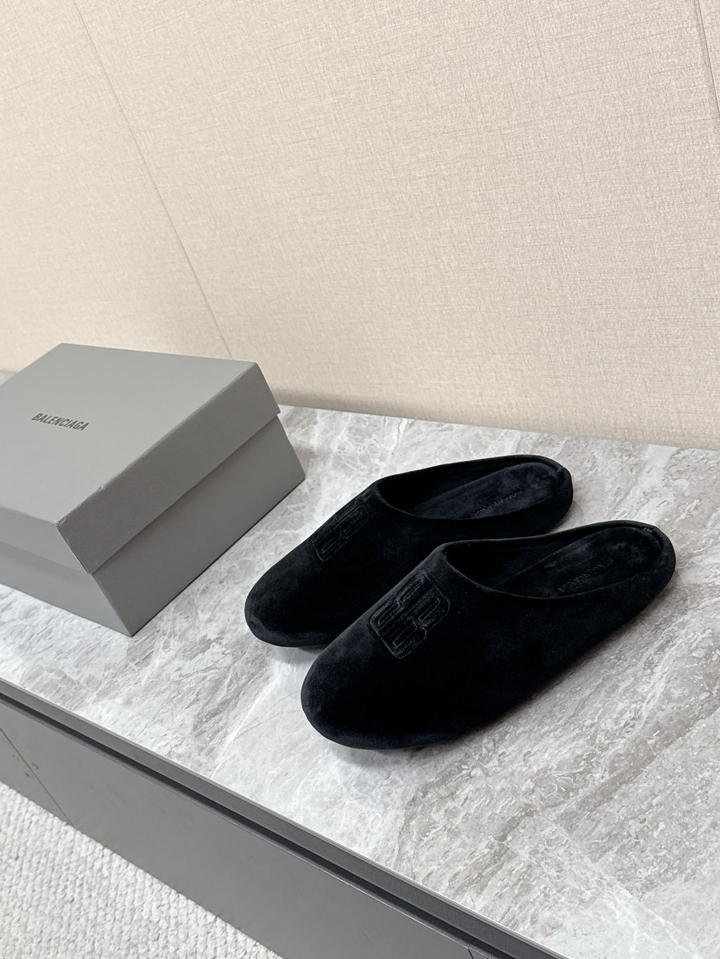 Black slide sandals with embossed Balenciaga logo, wide side view