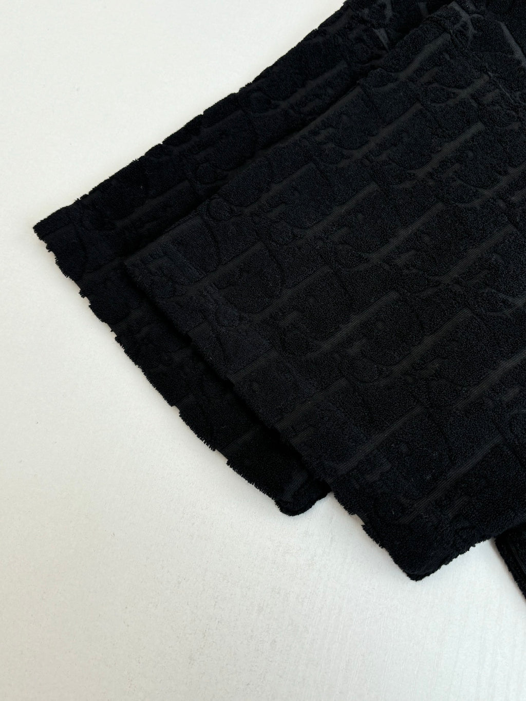 Textured knit fabric detail, dark allover logo pattern across sleeve