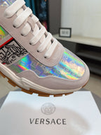 Light gray lace-up sneakers with iridescent logo graphic and chunky rubber sole.