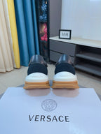 Versace sneakers heel view, black uppers with white midsoles and tan rubber soles