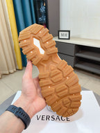 Versace luxury sneaker outsole, tan tread sole shown in hand