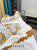 Versace luxury sneaker, white upper with gold patterned side panel and chunky sole