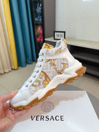 Versace luxury high-top sneakers, white with gold logo print, side angle on box