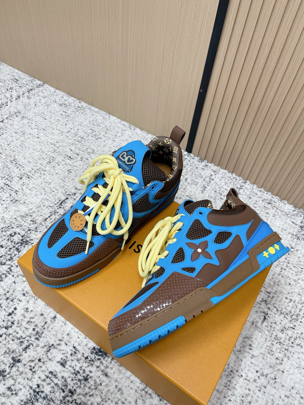 Pair of unisex sneakers, blue uppers with neon yellow laces and star-style cutouts