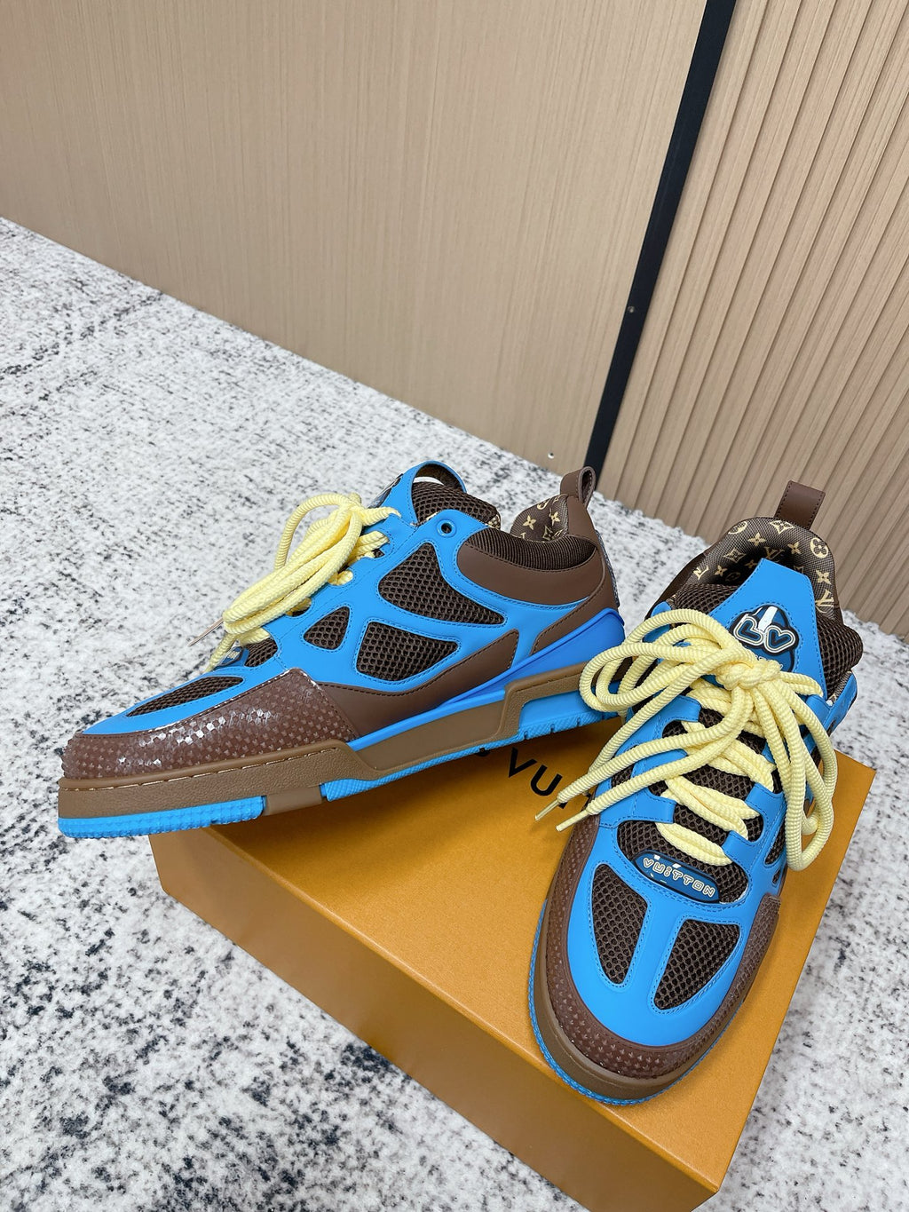 Unisex sneakers with blue panels, dark brown base, and neon yellow lace-up front