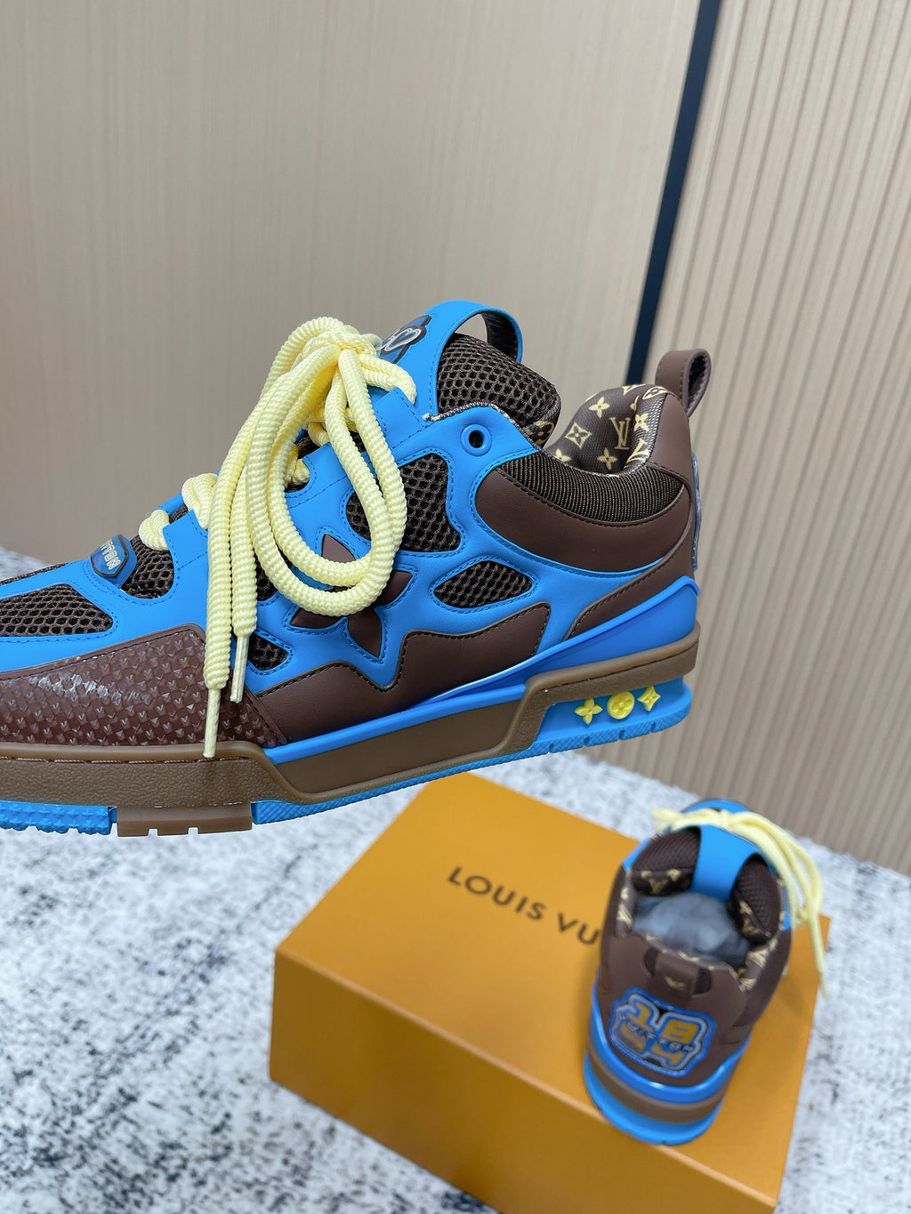 Unisex sneakers side view with blue upper, dark brown sole, and neon yellow laces