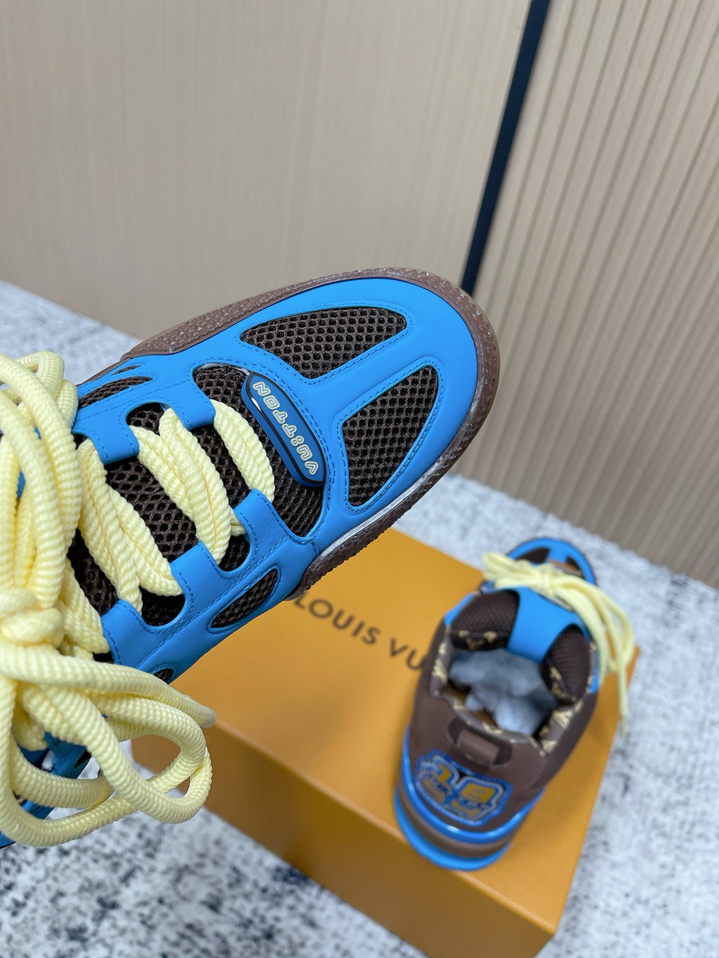 Unisex sneaker toe and side view with blue outsole trim and neon yellow laces