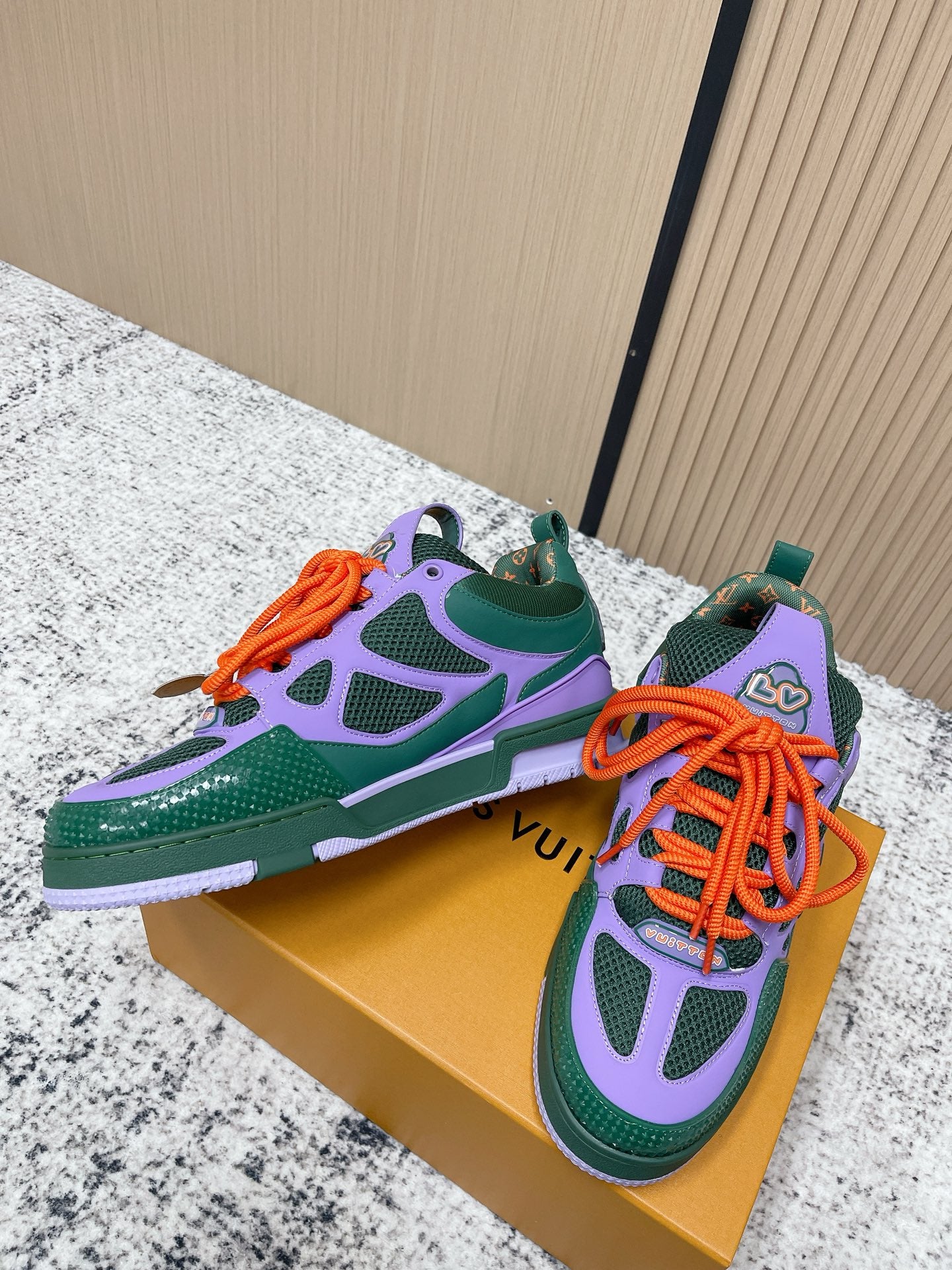Louis Vuitton unisex low-top sneakers with purple star pattern and orange laces.