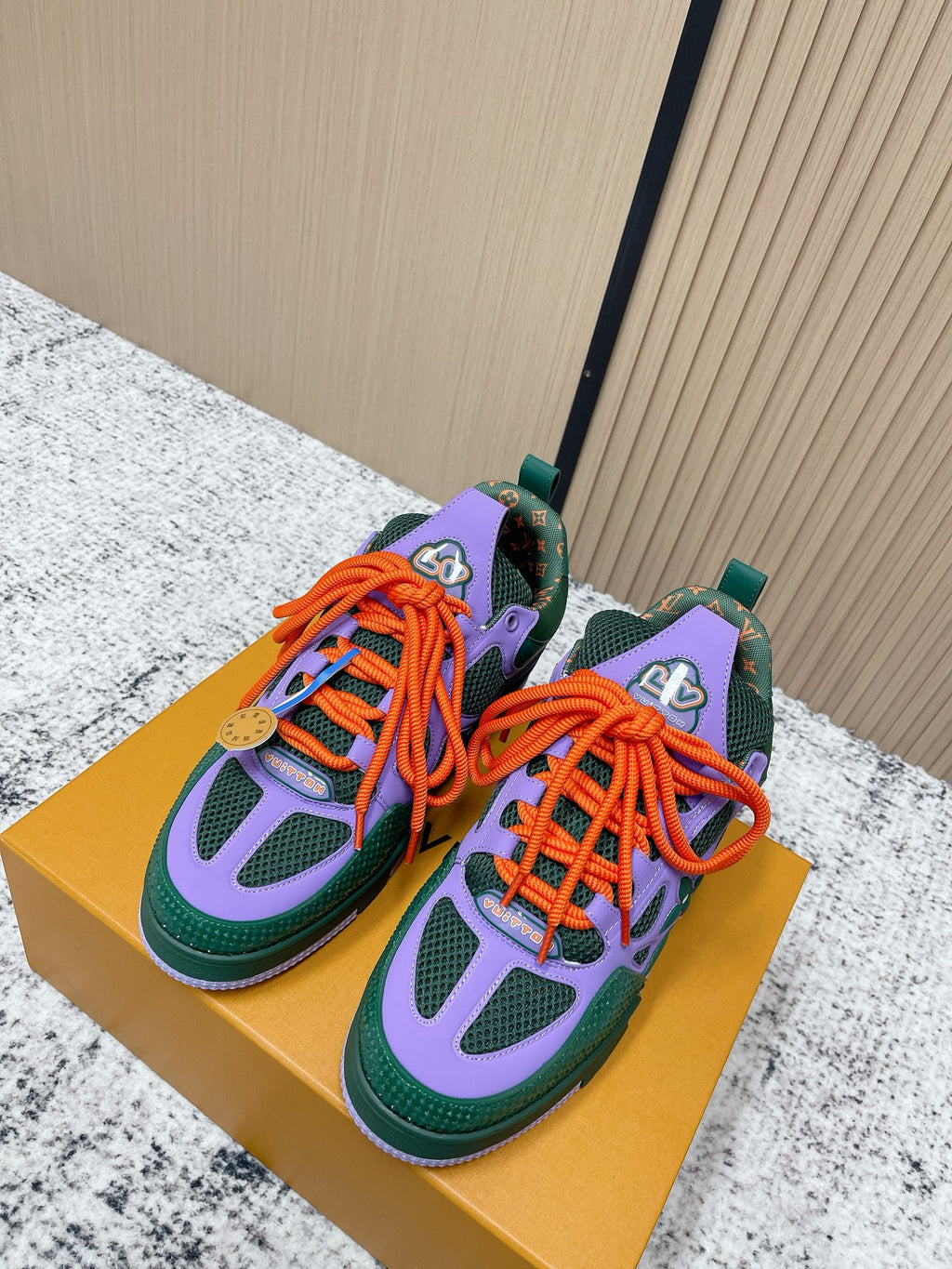 Louis Vuitton unisex sneakers in green, purple, and orange with lace-up front.