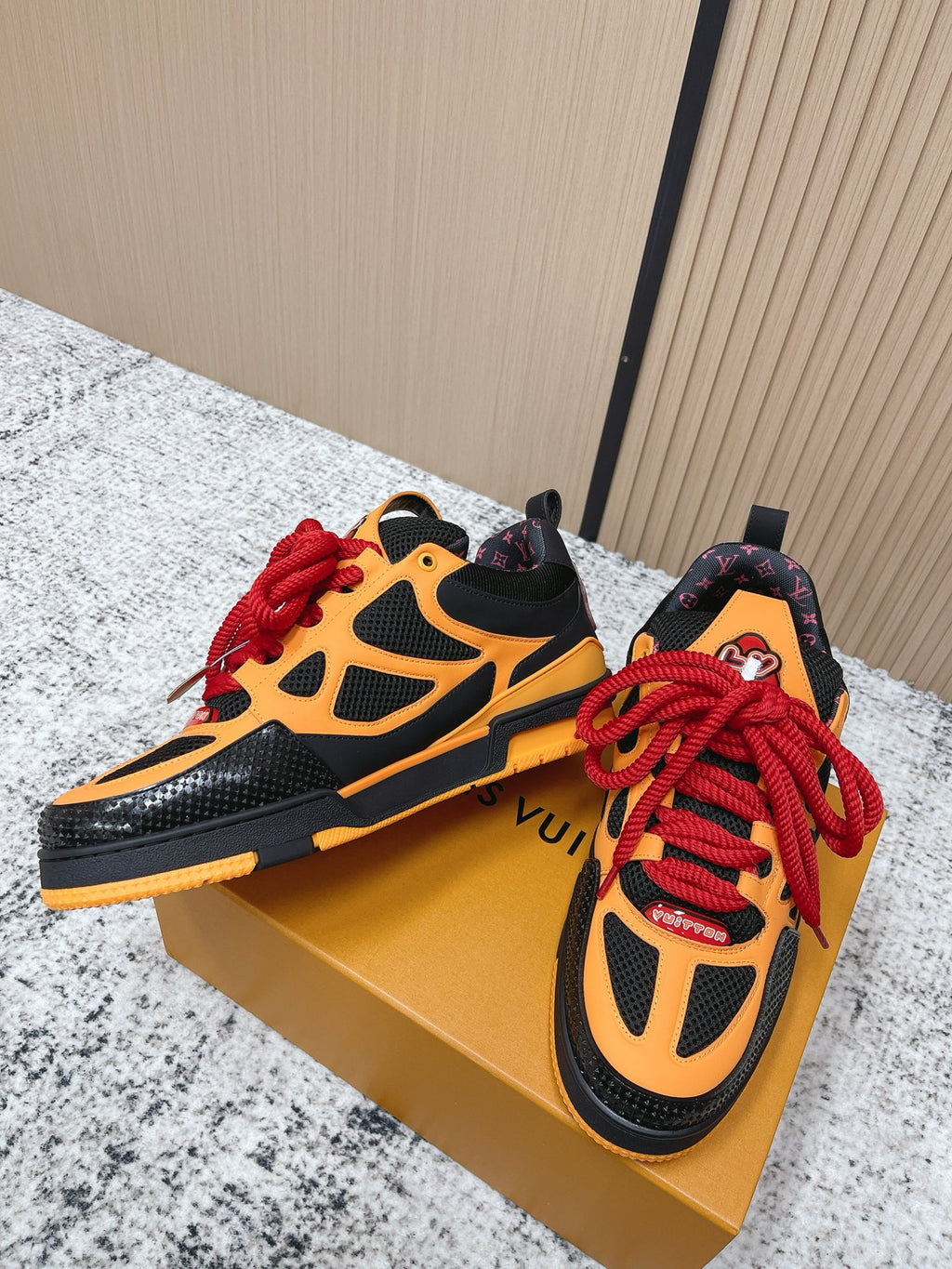 Orange and black high-top sneakers with red laces and patterned heel collar detail.