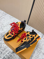 Black and orange lace-up sneakers on gold box, red laces and multicolor accents.