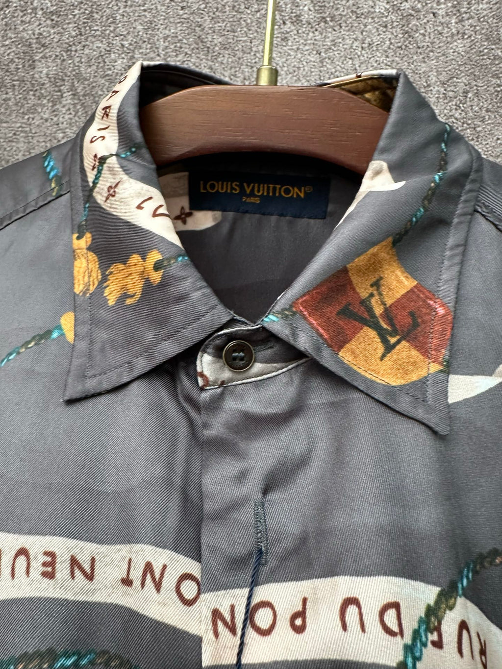 Long-sleeve button-up shirt neckline and logo label on dark blue graphic print.