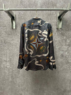 Long-sleeve button-up shirt in dark blue with all-over chain, animal, and rope pattern.