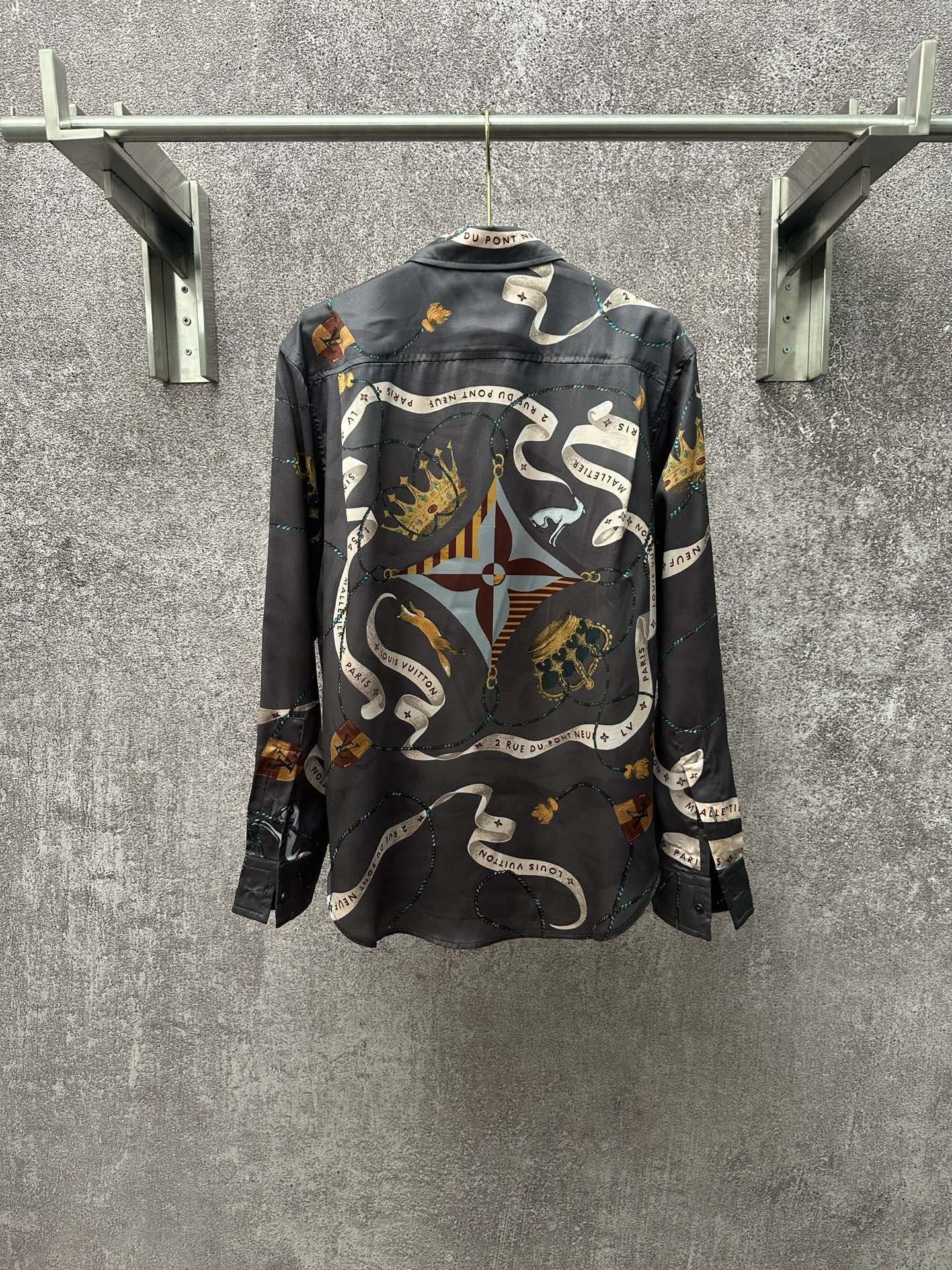 Long-sleeve button-up shirt in dark blue with all-over chain, animal, and rope pattern.