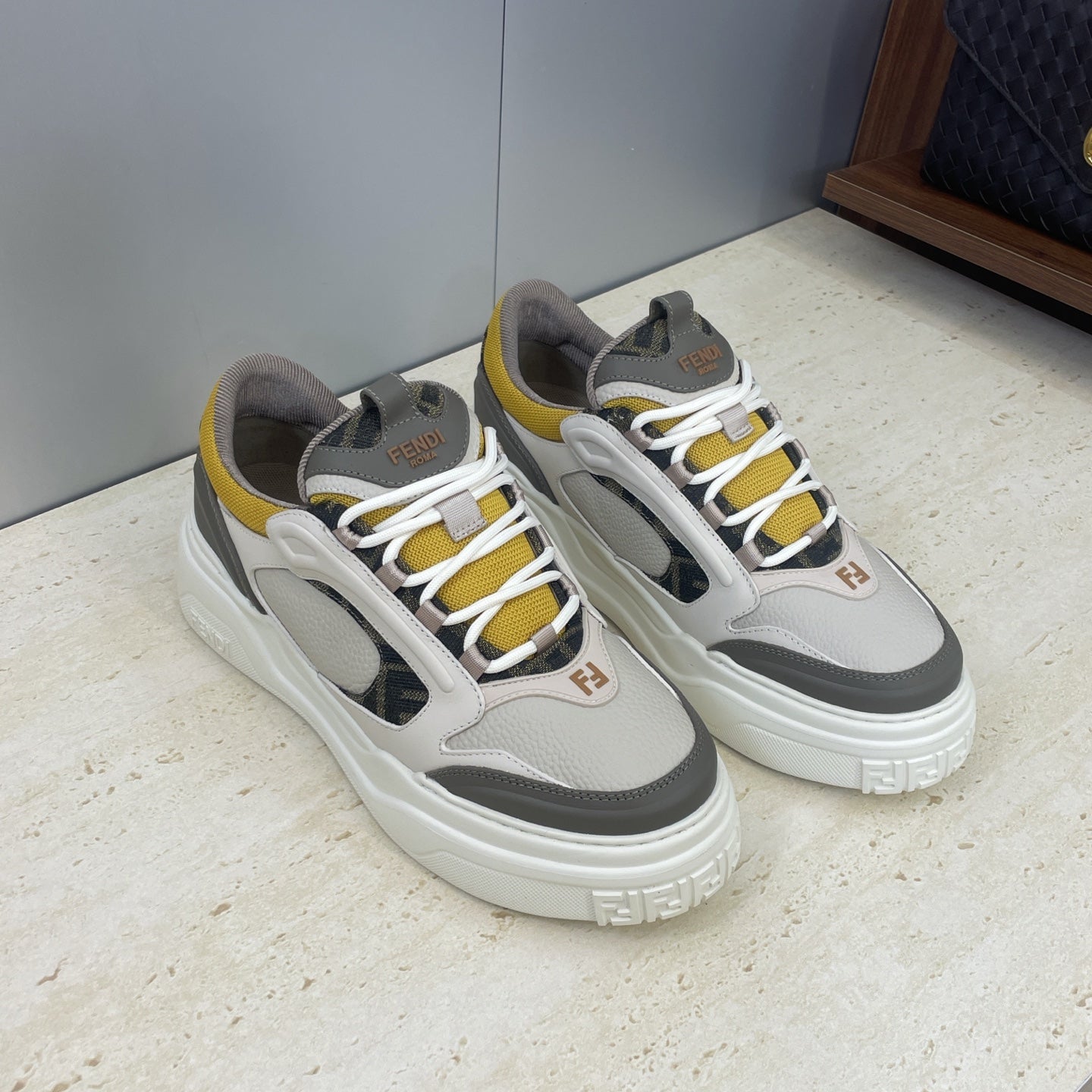 Fendi unisex sneakers pair, light gray leather with white laces, yellow accents, black inserts