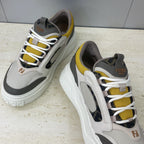 Fendi unisex sneakers close view, light gray leather with black side stripe and yellow trim