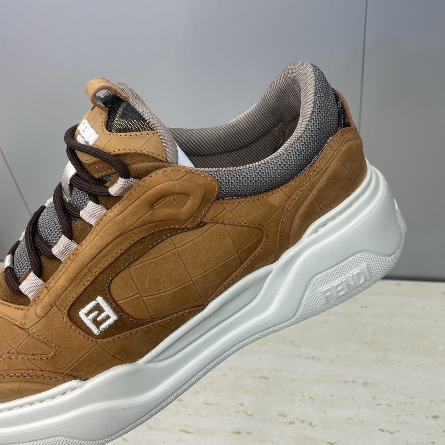 Close-up of tan Fendi unisex sneaker side with gray collar and white sole detailing