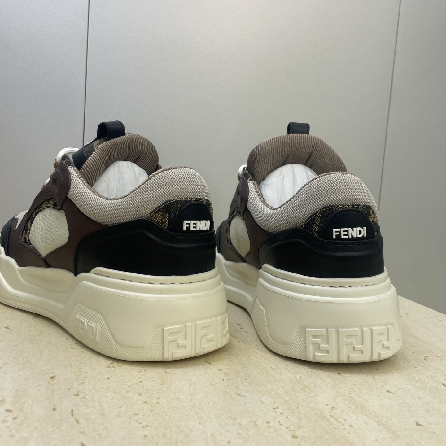 Unisex sneakers back view, beige heel with Fendi logo and dark upper