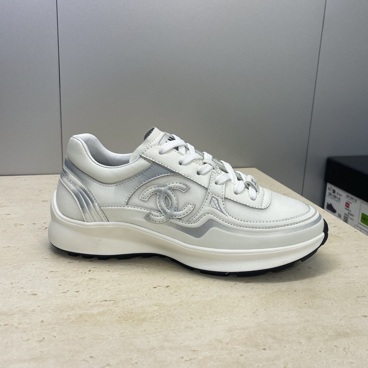 White Chanel unisex lace-up sneakers, side profile with logo detailing
