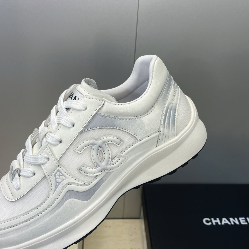 White Chanel unisex lace-up sneakers, close-up of side emblem and laces