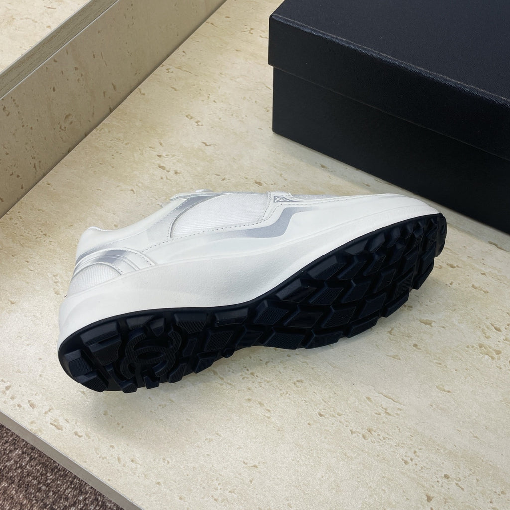 White Chanel unisex sneakers, outsole tread view with dark rubber pattern
