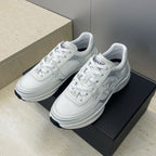 White Chanel unisex lace-up sneakers, side view with CC-style emblem