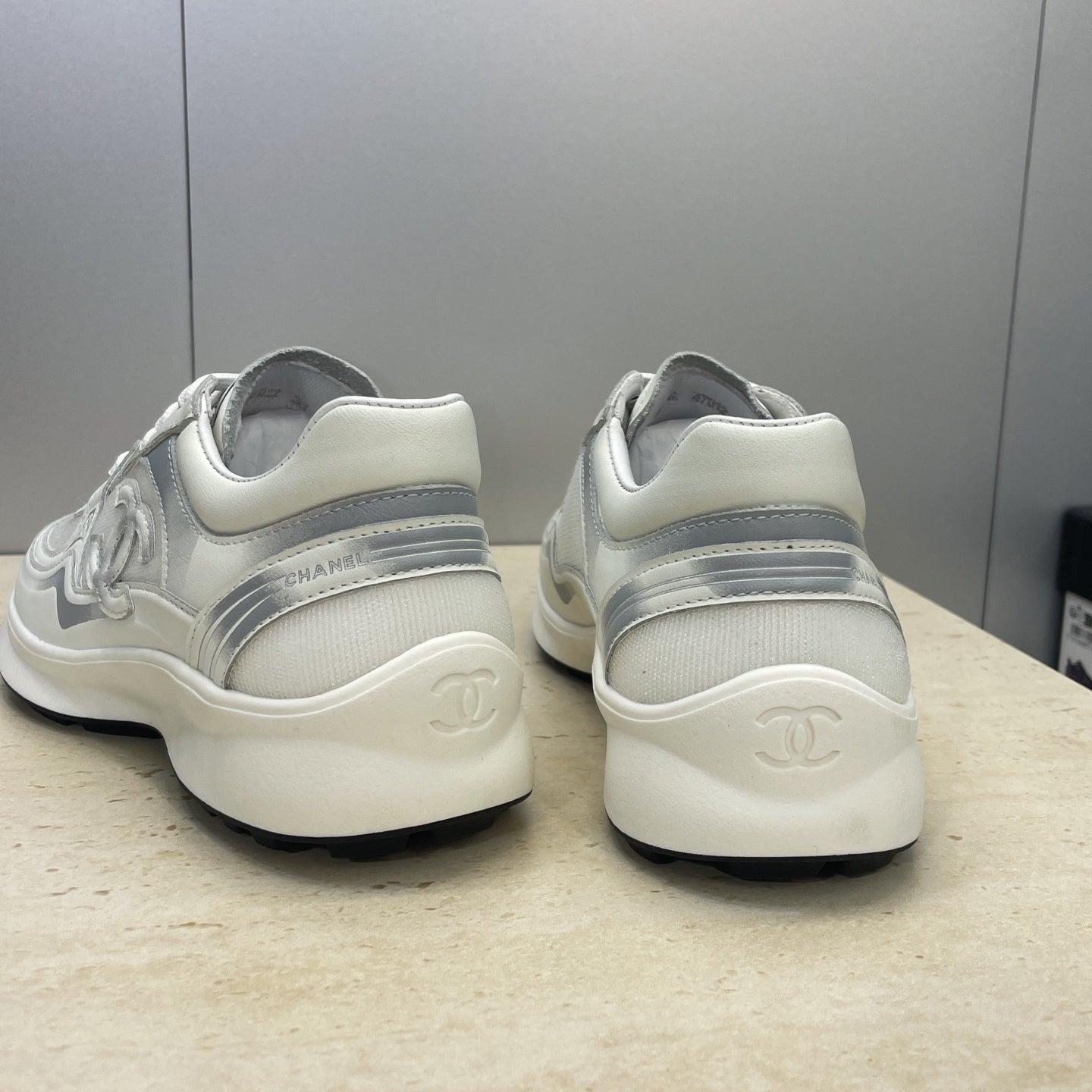 White Chanel unisex sneakers, heel view with logo embossing on back