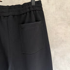 Black pants with front patch pocket and elastic waistband, side seam detail