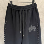 Black wide-leg pants, elastic waistband with drawstrings; side stud stripes and cross emblem