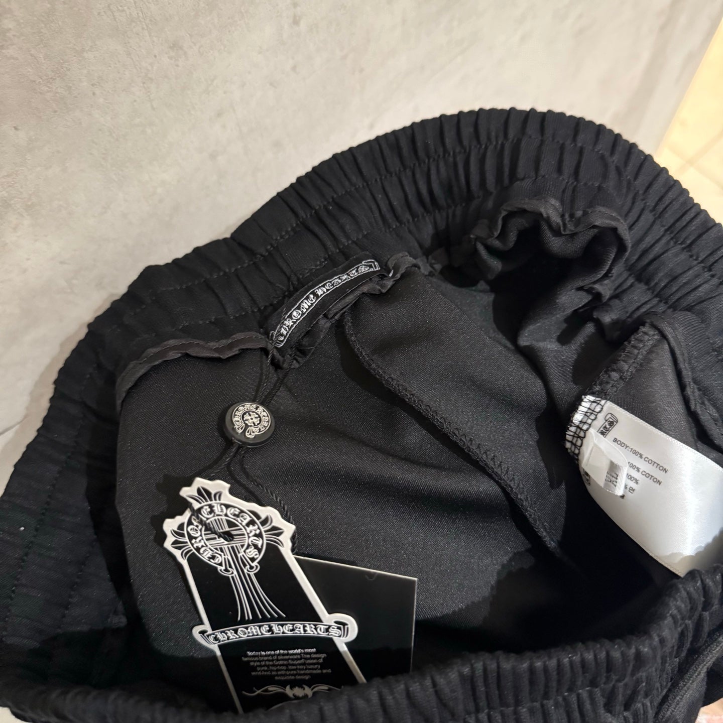 Black pants inner waistband with drawstring and care label inside