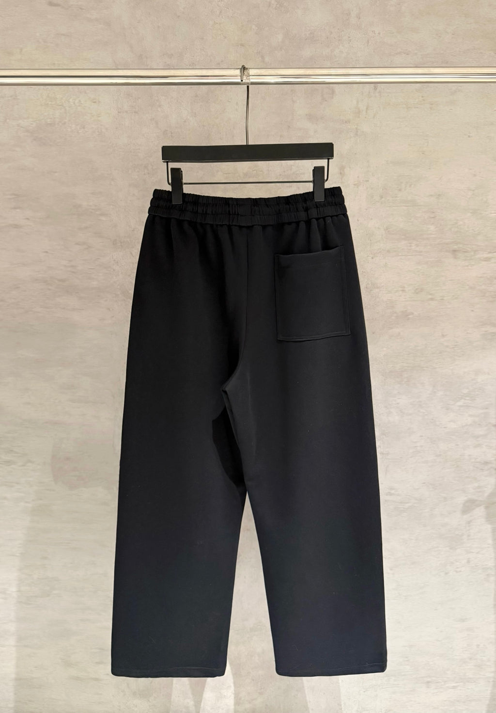 Black drawstring pants with elastic waistband and front patch pocket, wide leg