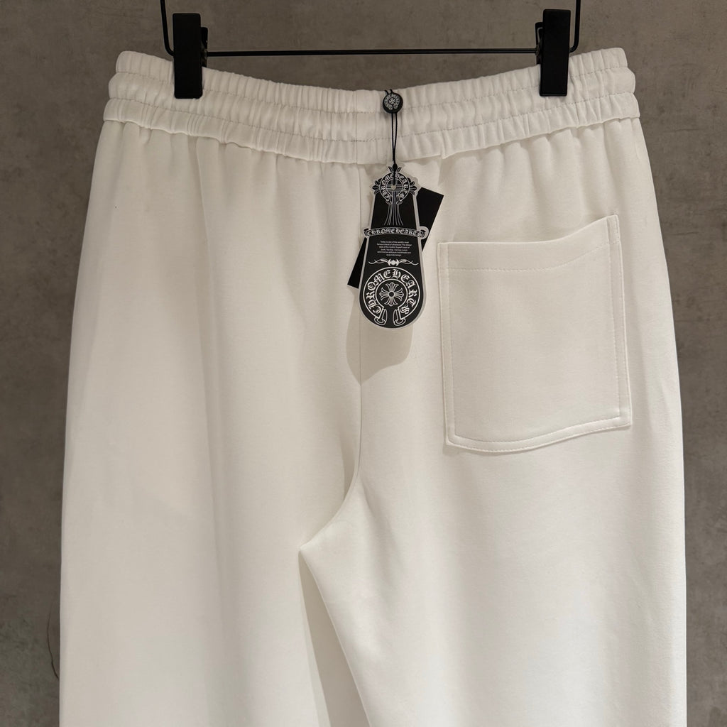 White cropped pants with elastic waist, side pocket, and hanging brand tag