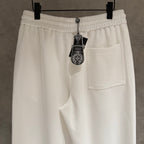 White cropped pants with elastic waist, side pocket, and hanging brand tag