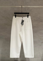 White cropped pants with elastic waist, side pockets, and hanging brand tag