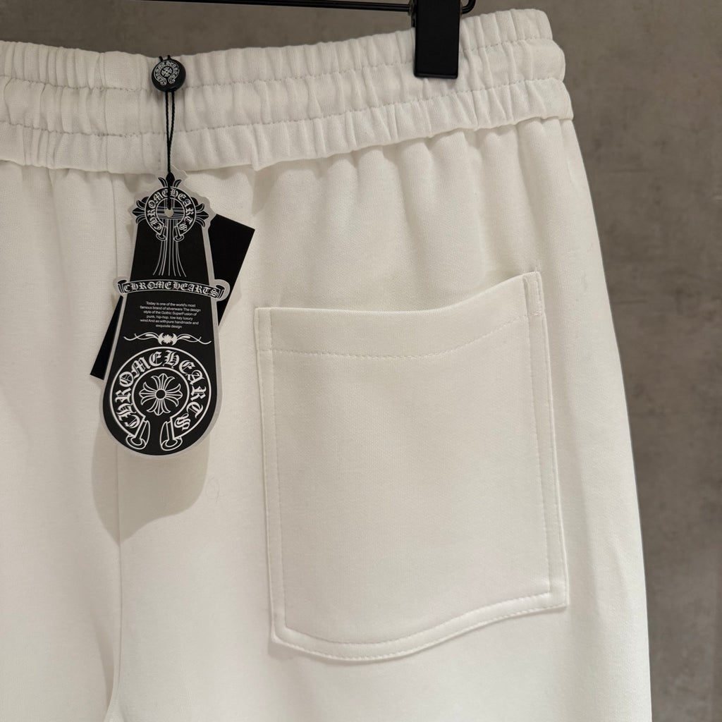 White cropped pants with elastic waist, side pocket, and hanging label on strings