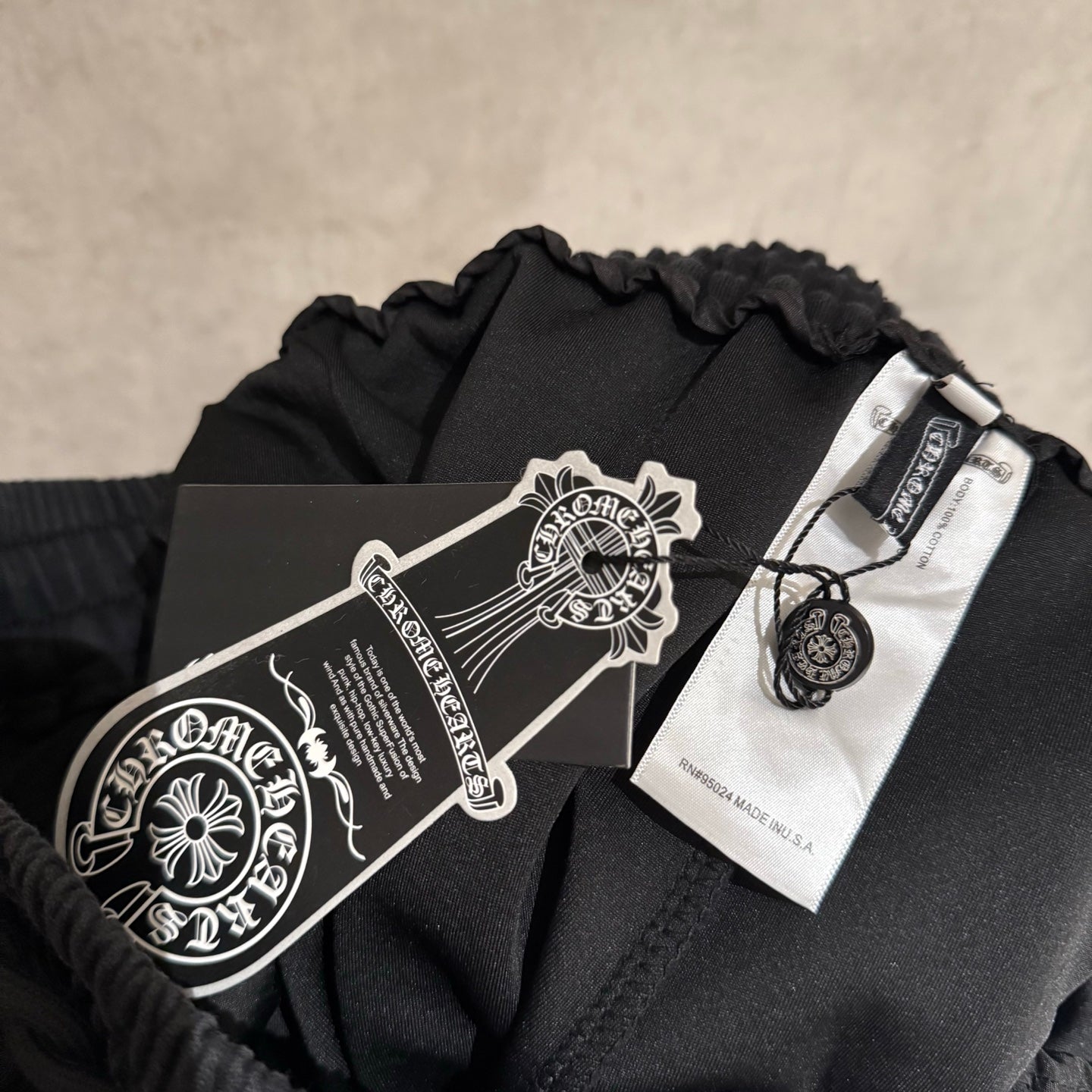 Dark pants with drawstring and elastic waist, care tag attached