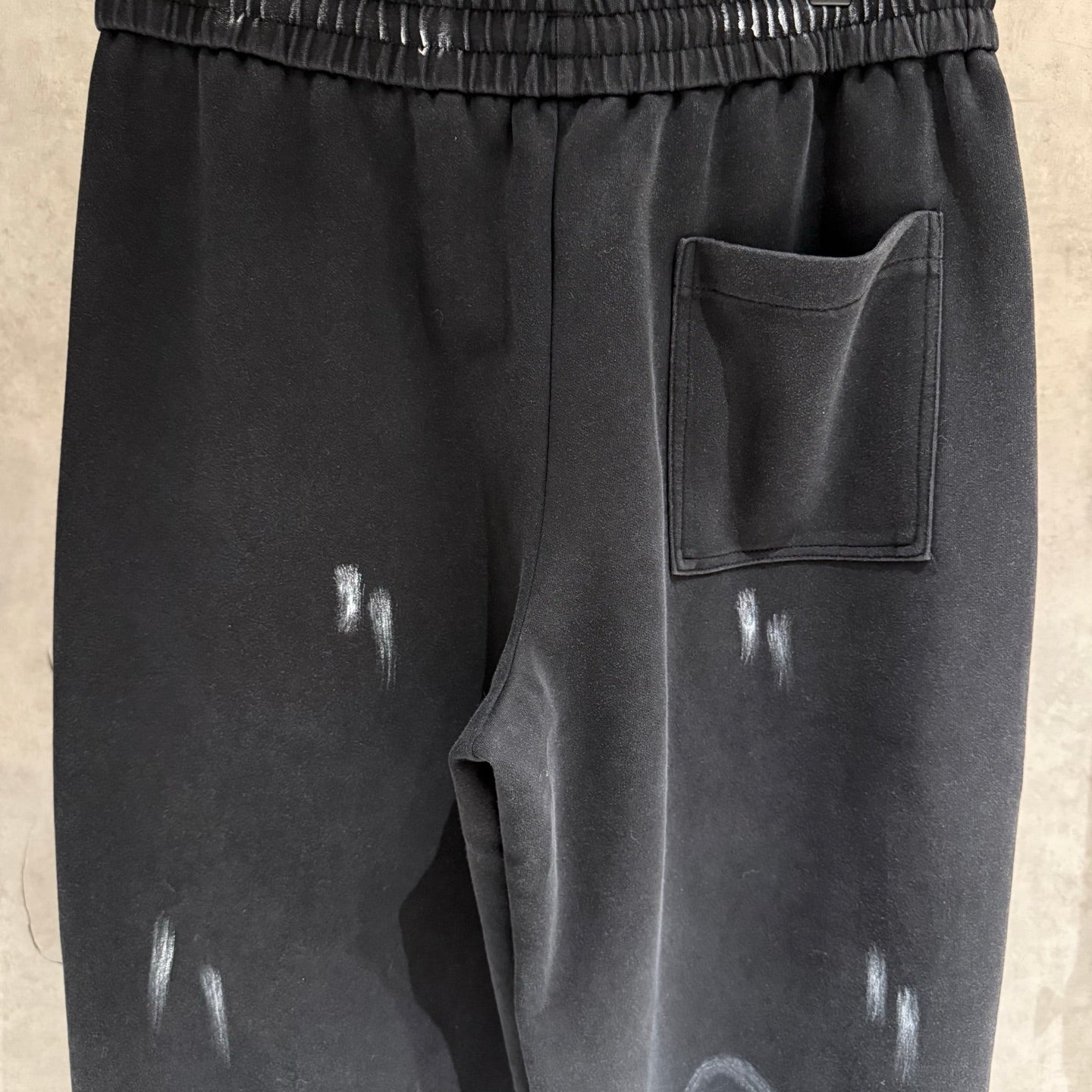 Dark pants with elastic waist, side pocket, drawstring, glossy splash marks