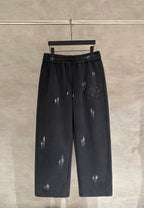 Black wide-leg pants with elastic waistband, drawstring, and glossy scattered patches