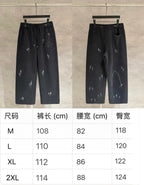 Dark pants shown front and back views, elastic waist with drawstring, glossy splash print