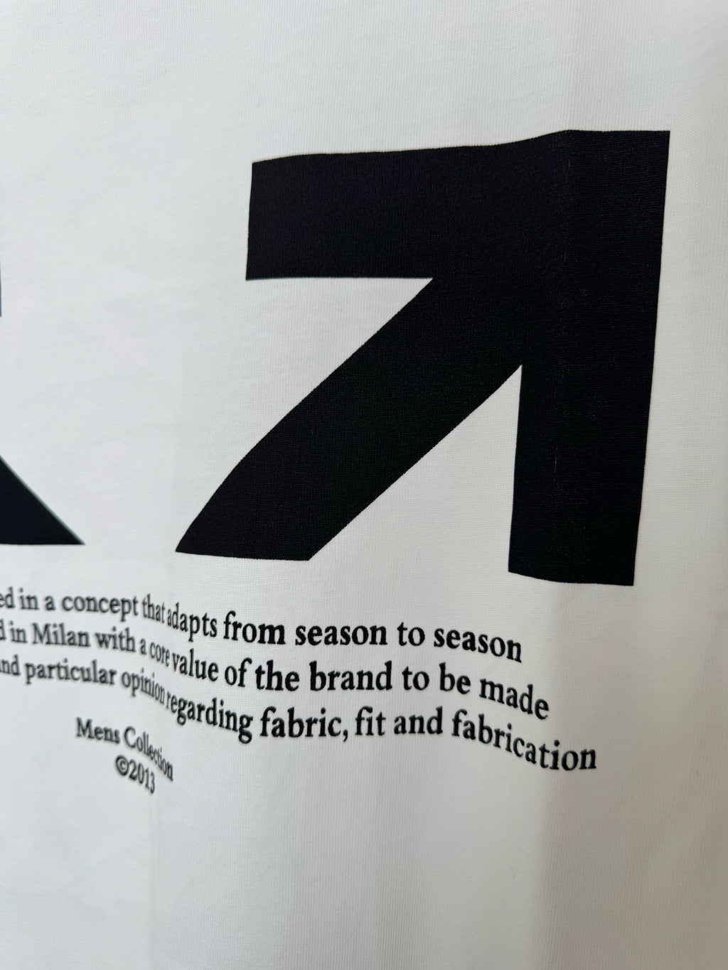 Off-White white T-shirt with large black arrow graphic and small text, close-up
