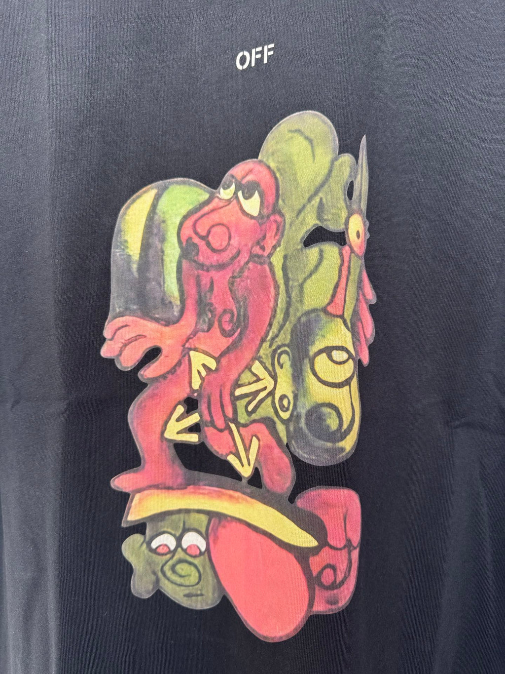 Black T-shirt with large multicolor cartoon print featuring three faces