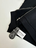 Black hoodie close-up with metal zipper and hanging brand tags
