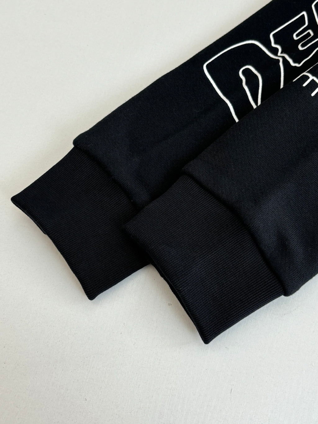 Black long-sleeve top with ribbed cuffs and hem