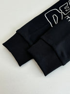 Black long-sleeve top with ribbed cuffs and hem