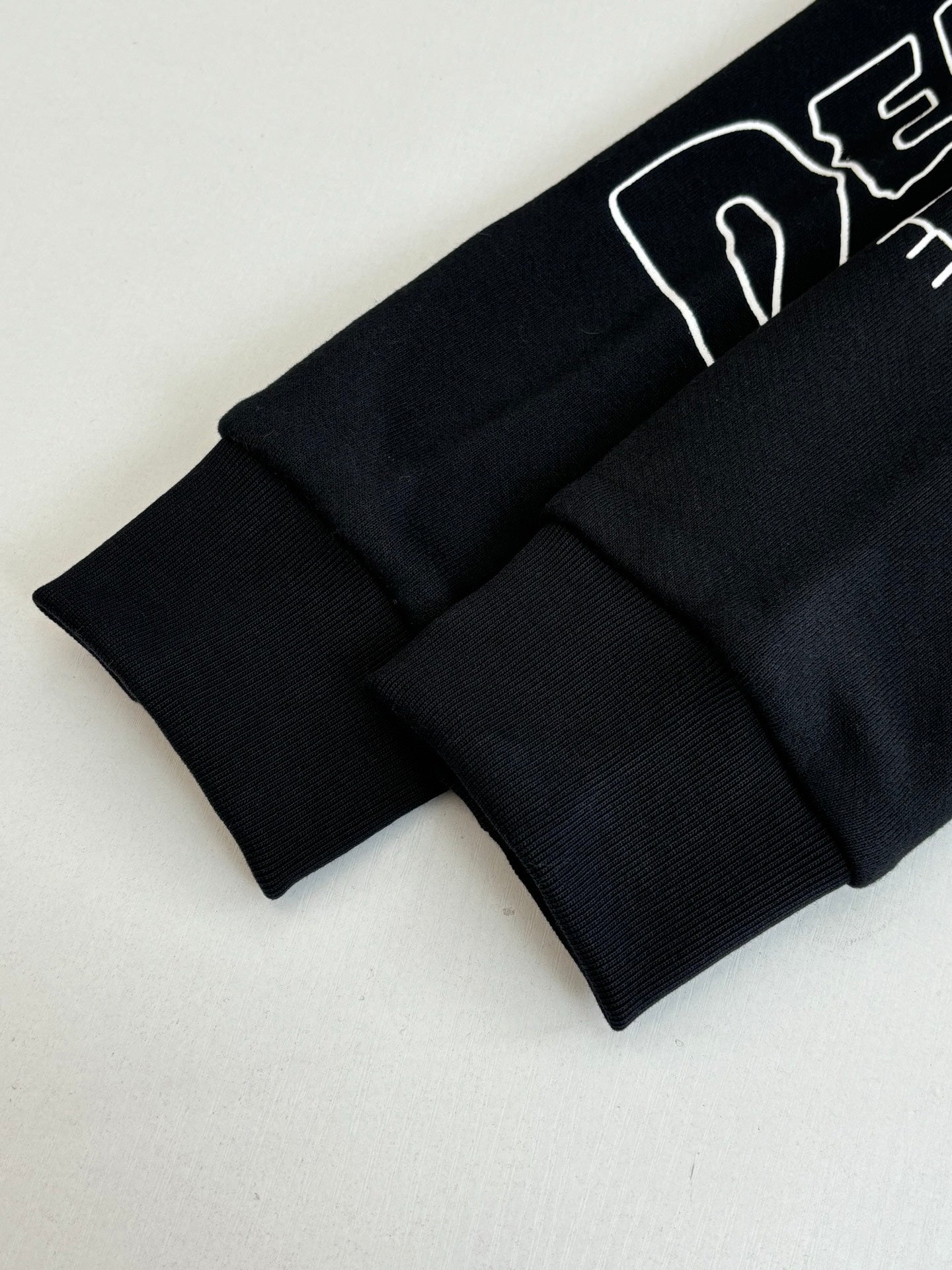 Black long-sleeve top with ribbed cuffs and hem